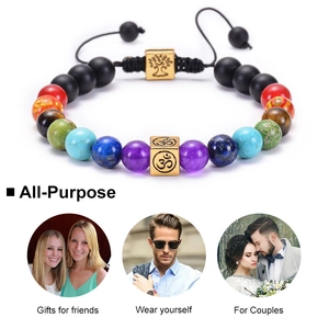 7 Chakra lava stone bracelet with OM and Tree of Life charms on white background