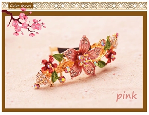 Detailed macro view of vintage hand-painted floral hair clip with crystals and pink enamel