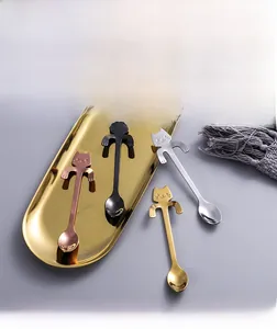 Detail of four-piece stainless steel cat-shaped coffee spoons in various metallic finishes