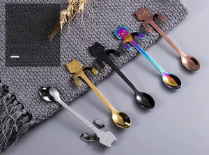 Detail of 304 stainless steel cat-shaped spoons hanging on cup rim in five colors