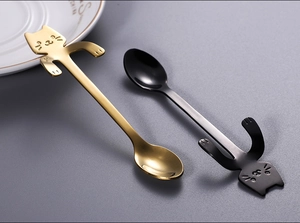 Close-up of cute cat-shaped coffee spoons in gold and black stainless steel finish