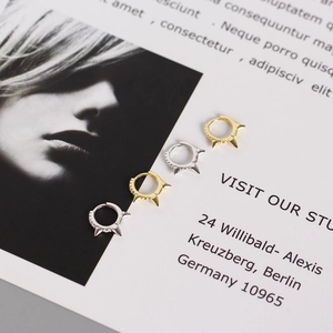 Detail of gold and silver punk spike hoop earrings with rivet studs on fashion magazine