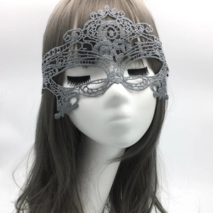 Macro view of silver lace masquerade mask showing intricate hollow patterns and glitter texture