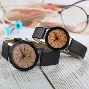 Minimalist quartz watches with black leather straps and golden dials on a desk setup