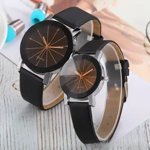 Close-up of couple's quartz watches with black leather straps and chocolate brown dials