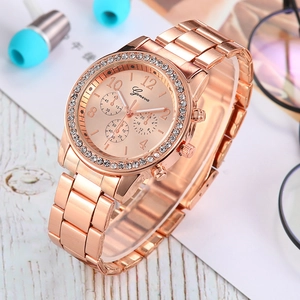 Rose gold Geneva women's watch with crystal bezel and steel strap on a white wooden surface