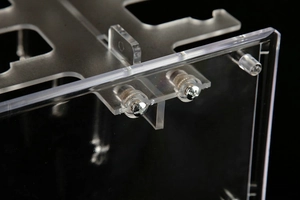 Close-up of clear acrylic display stand showing assembly screws and transparent material