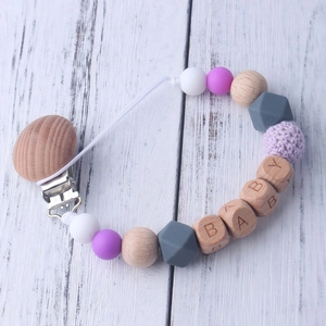 Detail of wooden baby pacifier clip with silicone beads and BABY letter beads