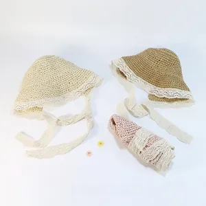 Vue de dessus de chapeaux de paille crème, marron et rose avec de fins rubans en dentelle