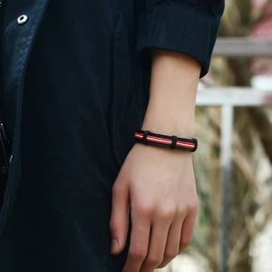 Black and red braided faux leather bracelet for men and women in a lifestyle setting