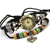 Close-up of vintage bronze watch head with black braided leather strap and heart charm