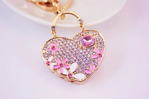 Close-up of heart keychain with pink flowers, sparkling rhinestones and crystal charm
