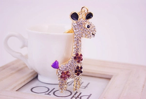 Close-up of golden giraffe keychain with purple and clear crystal rhinestones detail