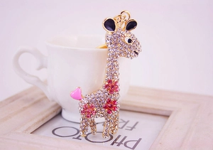 Macro view of crystal-encrusted giraffe keychain with pink rhinestone flower patterns
