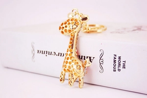 Close-up of golden crystal giraffe keychain placed on a book with a blurred background