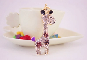 Detailed macro of golden giraffe keychain with purple rhinestones and enamel accents