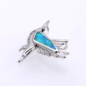 Close-up of bird pendant featuring blue-green opal stone inlay and silver-tone metal textures