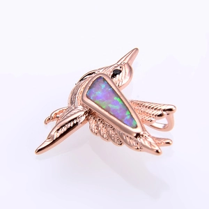 Detail of rose gold hummingbird pendant with opal inlay and delicate feather textures
