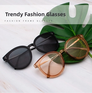 Detail of vintage square sunglasses in black and amber frames on marble with leaf