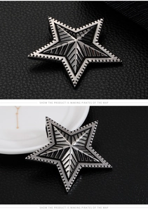 Detail of silver stainless steel star pendant with embossed texture on leather background