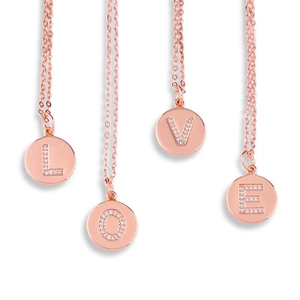 Detail showing four rose gold necklaces with sparkling rhinestone initials spelling LOVE