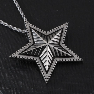 Polished silver stainless steel star pendant with intricate leaf patterns on rope chain