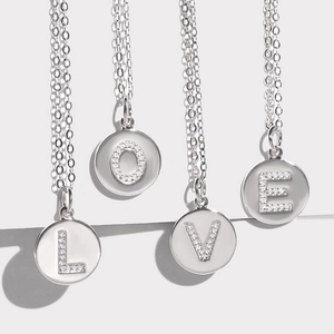 Silver round initial pendant necklace with cubic zirconia micro-paved letters L O V E