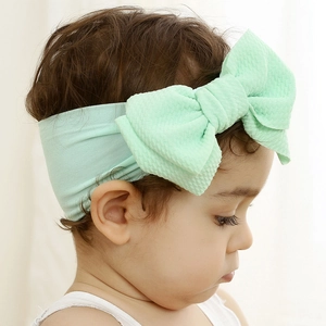 Detail of mint green knotted baby headband with soft elastic waffle fabric bow