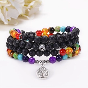 Detail of 108 lava stone chakra beads featuring a silver tree of life pendant on white