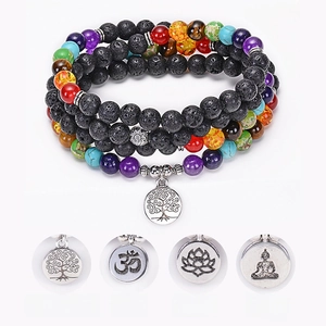 Macro detail of 108 lava stone mala beads with tree of life and lotus yoga charms
