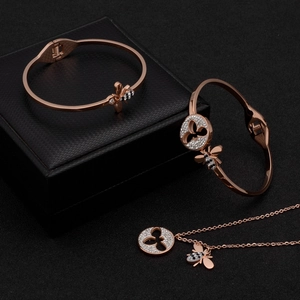 Parure de bijoux abeille or rose avec bracelets et collier sur écrin en cuir noir