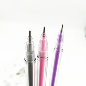 Macro shot of 0.5mm gel pen tips with silver, pink, and purple ink in clear barrels