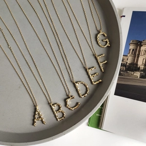 Macro detail of 925 silver golden letter pendants with vintage hammered texture finish