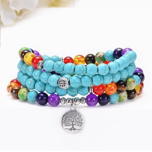 Detailed shot of turquoise chakra beads featuring a silver Tree of Life pendant charm