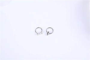Macro shot of surgical steel horseshoe barbell and hoop featuring skull motifs