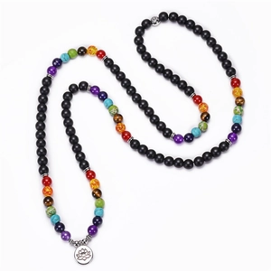 Gros plan du collier mala 108 perles avec pendentif lotus argenté et pierres de chakra