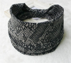 Detail view of wide bohemian elastic headband with grey and black snake skin print pattern