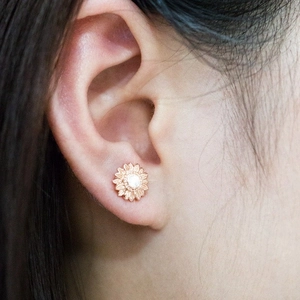 Elegant 18k rose gold sunflower stud earrings featuring a sparkling center gemstone
