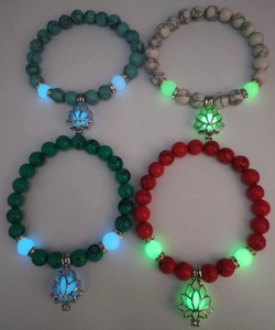 Luminous lotus pendants on turquoise yoga beads showing blue and green glowing effect