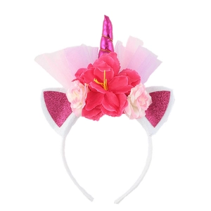 Macro shot of pink unicorn headband featuring large floral decor and glittering ears