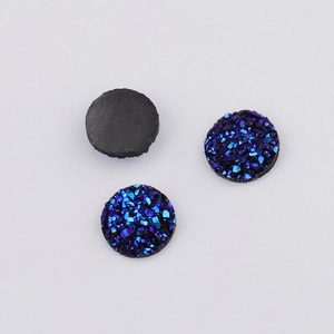 Macro detail of 10mm deep blue glitter resin cabochons with flat black back for DIY jewelry
