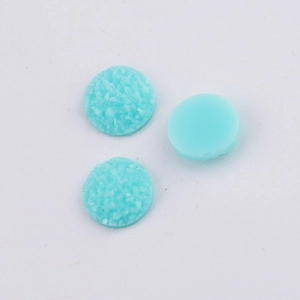 Close-up of 10mm light blue druzy resin cabochons showing faceted and smooth textures