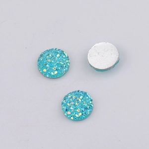 Macro shot of three teal 10mm resin druzy cabochons with sparkling textured surface