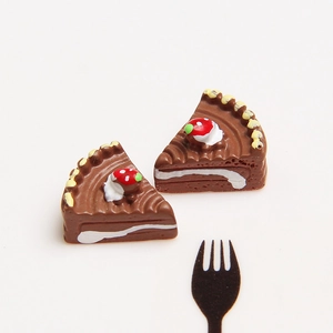 Macro shot of miniature resin chocolate cake slices with cream and strawberry detail