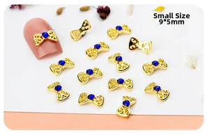 Detailed macro view of small 9x5mm gold hollow bow nail charm with blue rhinestone