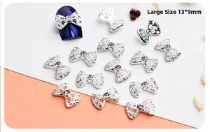 Macro view of 13x9mm hollow silver bow nail art charm with sparkling center rhinestone