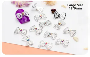 Detailed view of silver bow nail charms with hollow carving and rhinestones in 13*9mm size