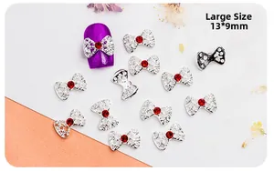 Detail view of large silver hollow bow nail art charms with red rhinestones, 13x9mm size
