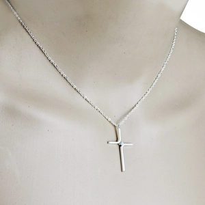 Minimalist titanium steel cross necklace with a small gemstone on a silver chain
