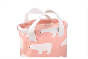 Close-up of pink canvas storage bin featuring polar bear print and durable side handles